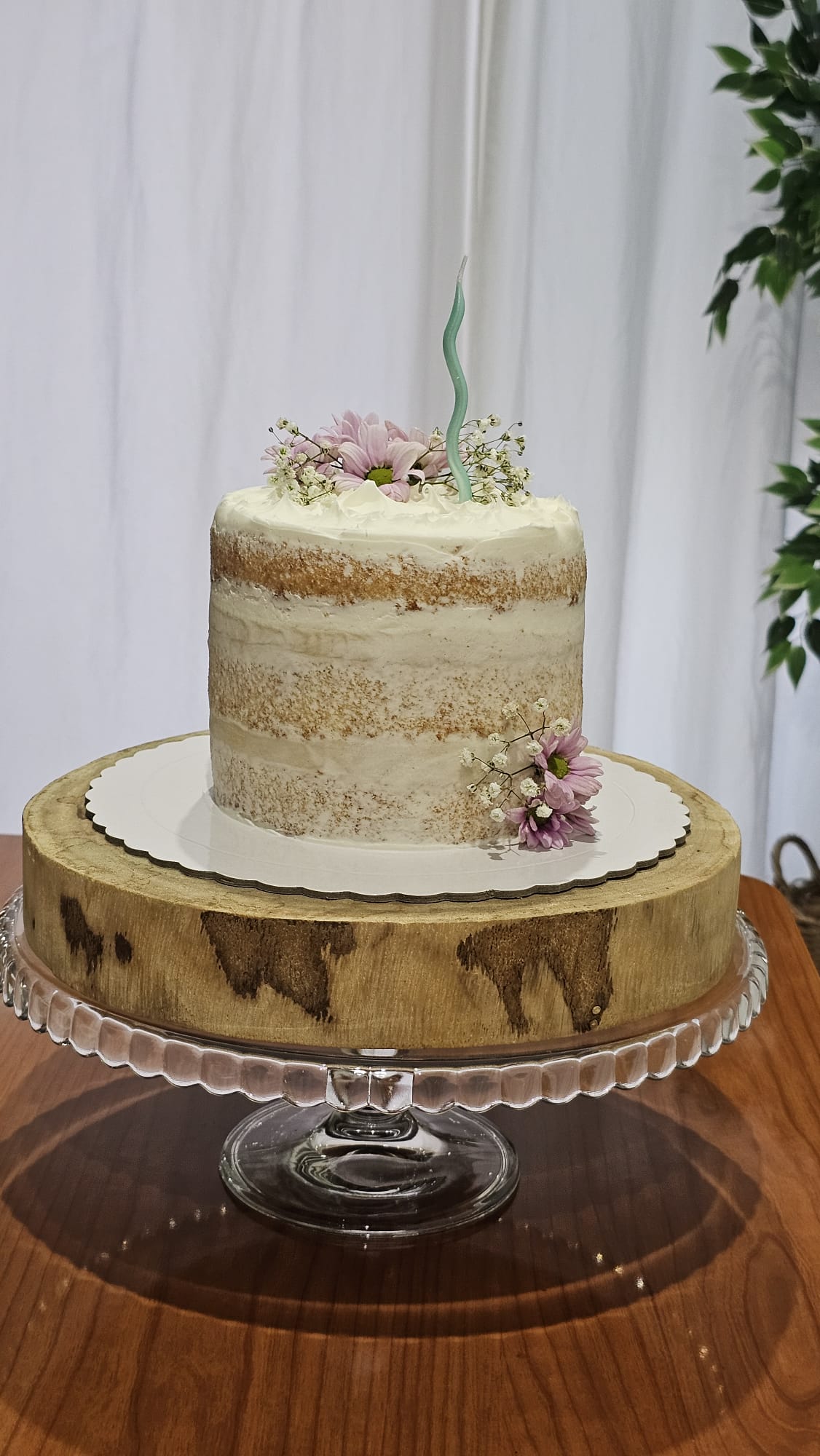 Naked cake con flores lilas y vela ondulada